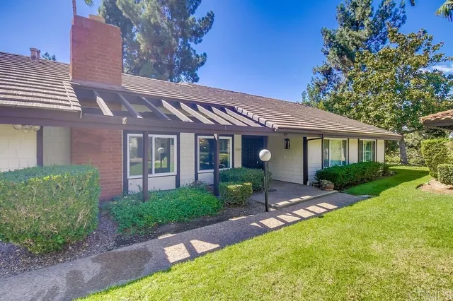 a front view of a house with a yard and outdoor seating