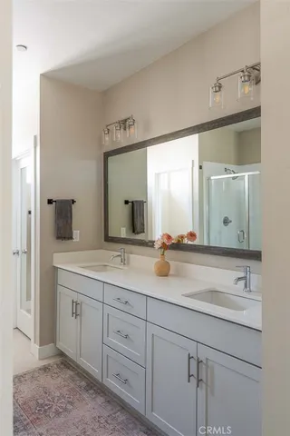 a bathroom with double sink and a mirror