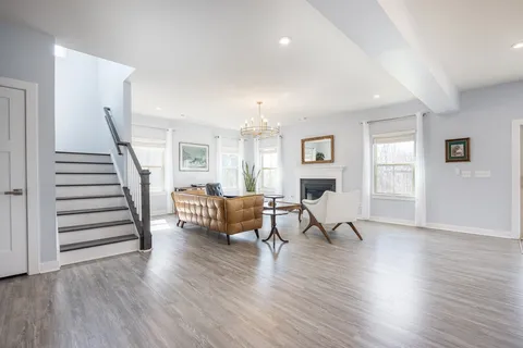 a living room with furniture and a wooden floor