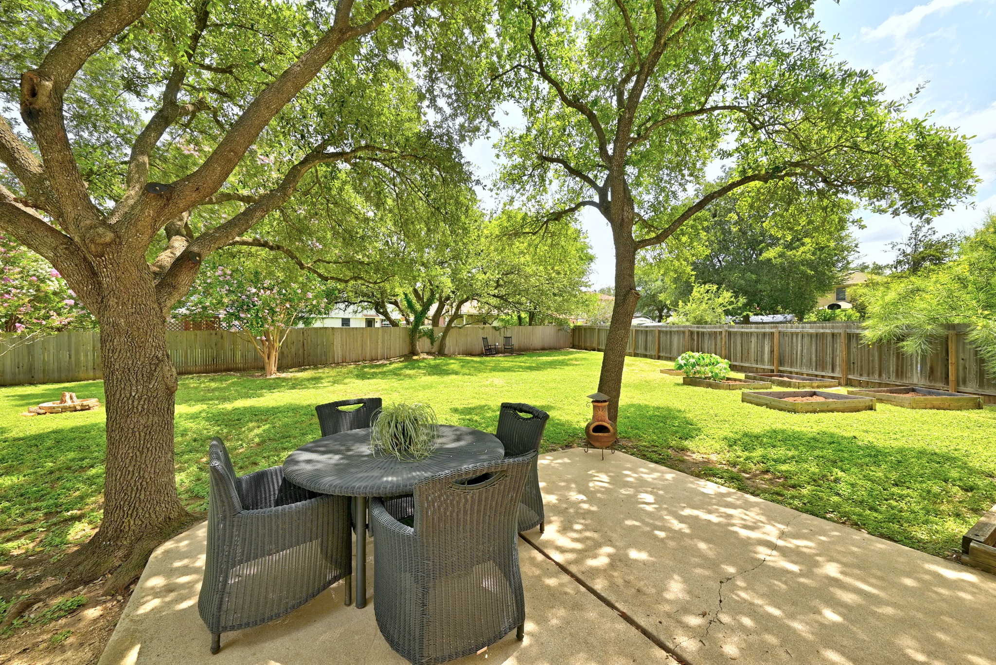 1801 Monks Tale Court Austin, TX 78748 - Photo 31 of 36 A spacious backyard retreat with mature trees, a concrete patio, and raised garden beds awaits.