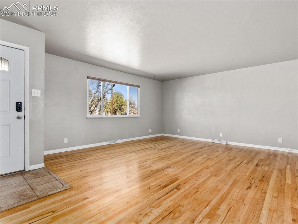65 University Circle Pueblo, CO 81005 - Photo 11 of 32 an empty room with wooden floor and windows