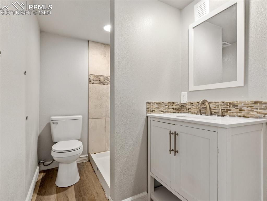 65 University Circle Pueblo, CO 81005 - Photo 26 of 32 a bathroom with a granite countertop toilet sink and mirror