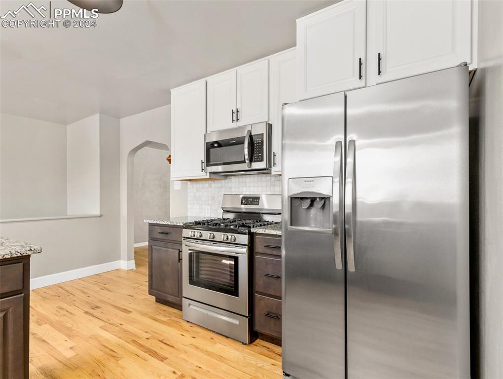 65 University Circle Pueblo, CO 81005 - Photo 7 of 32 a kitchen with stainless steel appliances granite countertop a refrigerator a stove a sink and white cabinets