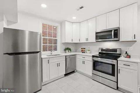 a kitchen with a refrigerator sink and cabinets