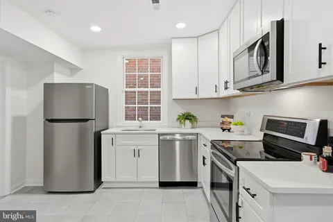 a kitchen with a dining table chairs and refrigerator