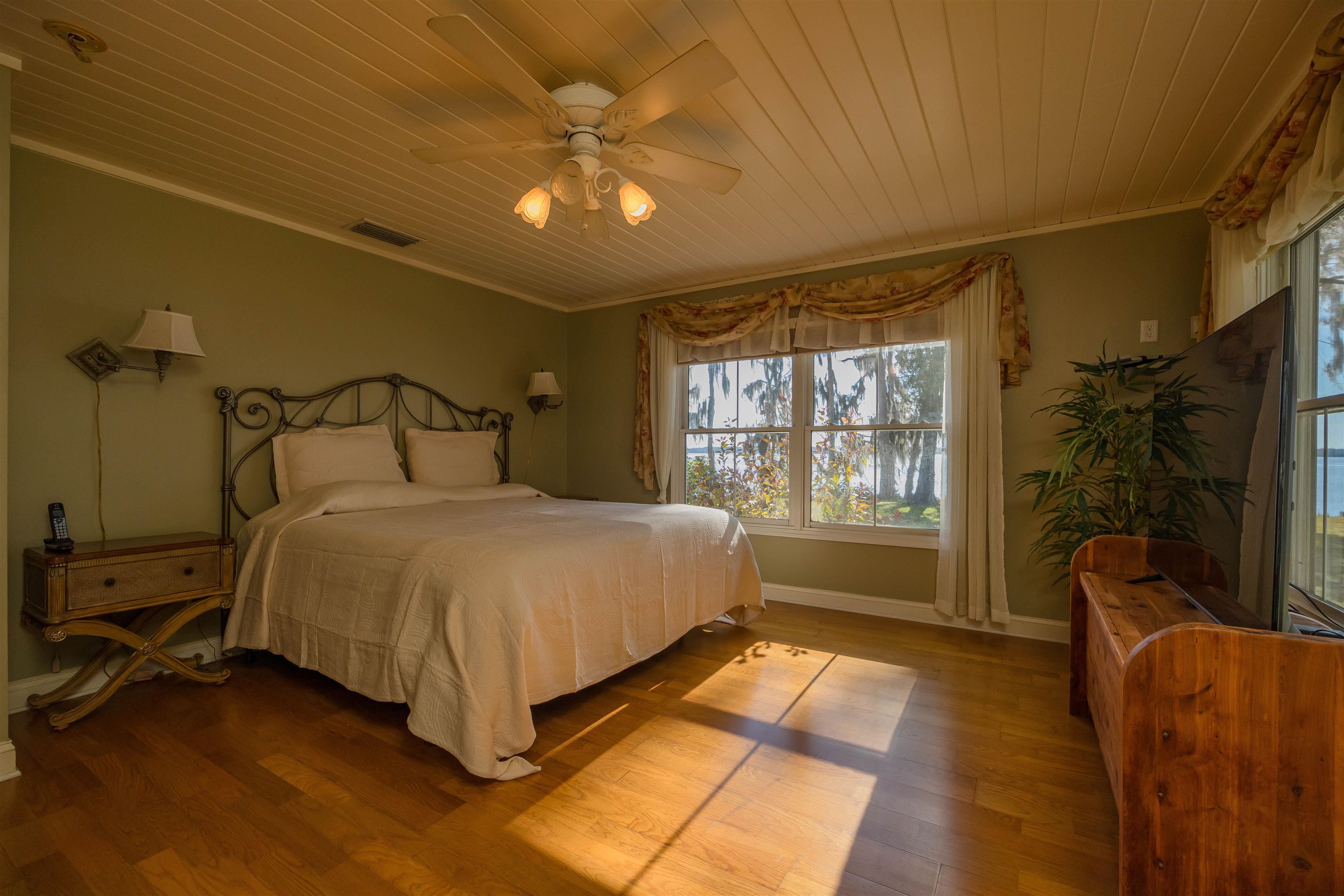 141 Wooten Rd Crescent Crescent City, FL 32112 - Photo 57 of 72 a spacious bedroom with a bed and a chandelier