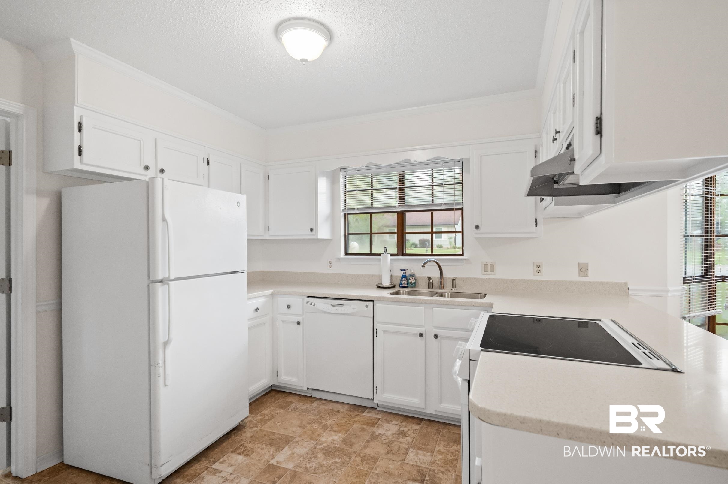 128 Dunbar Loop Daphne, AL 36526 - Photo 11 of 39 Kitchen featuring a textured ceiling, sink, white appliances, and white cabinets