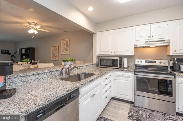 a kitchen with stainless steel appliances granite countertop a stove and a sink