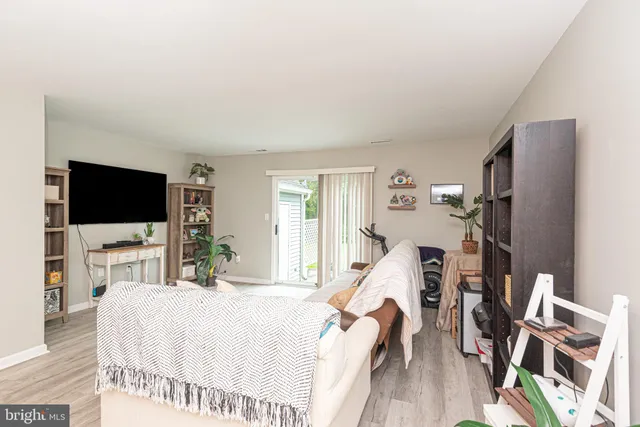 a bedroom with a bed a flat screen tv and a large window