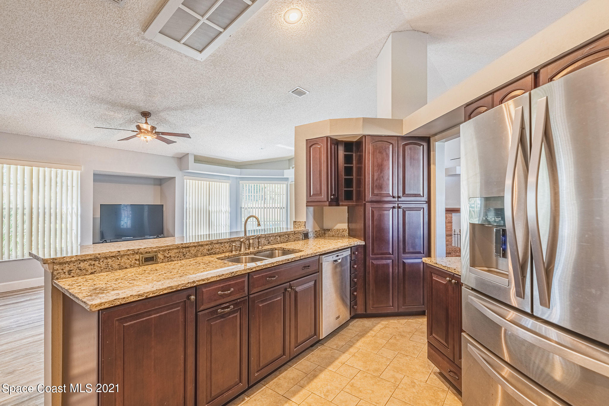 7207 Achilles Road Cocoa, FL 32927 - Photo 12 of 57 a kitchen with stainless steel appliances granite countertop a sink refrigerator and cabinets