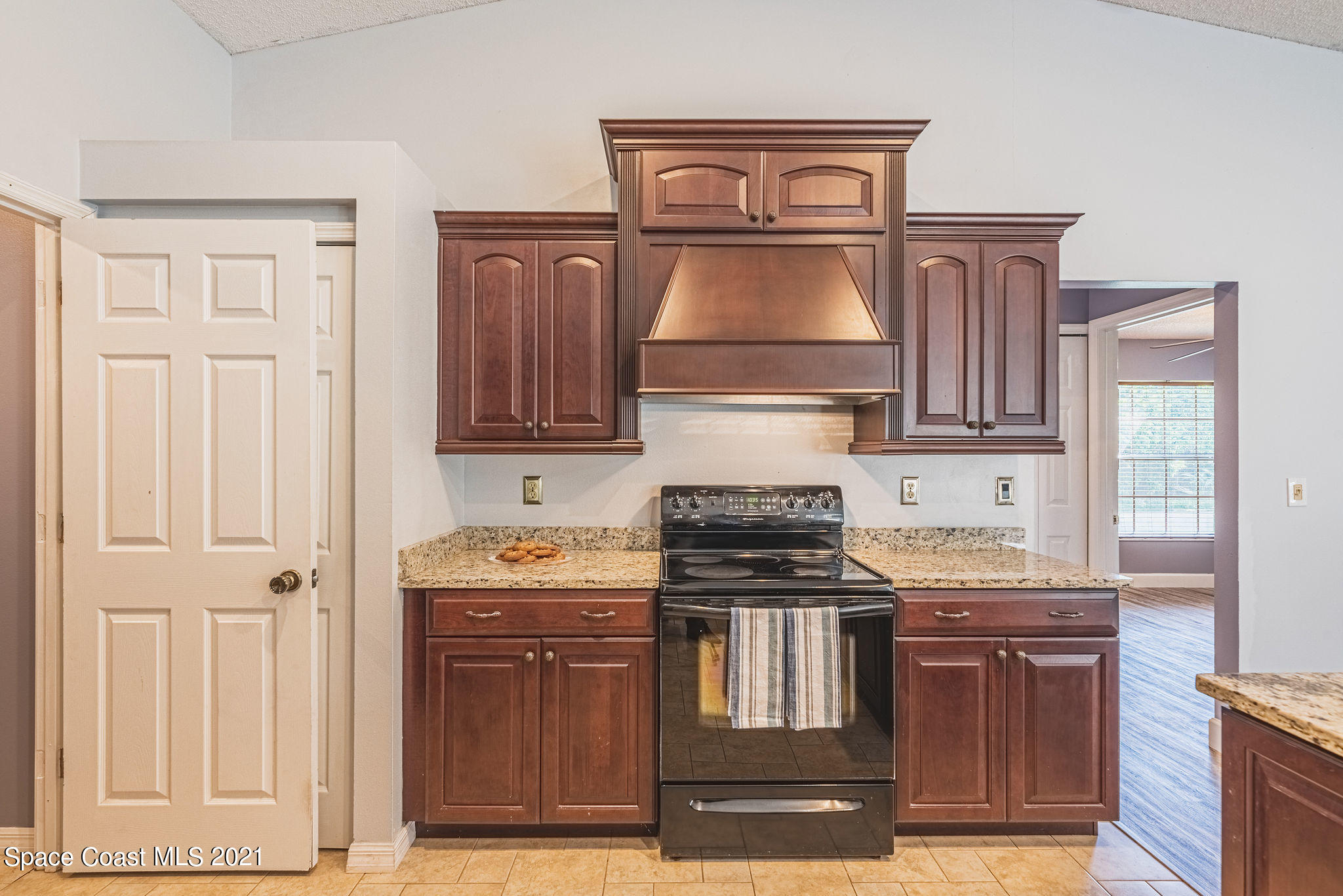 7207 Achilles Road Cocoa, FL 32927 - Photo 14 of 57 a kitchen with stainless steel appliances granite countertop a stove top oven and cabinets