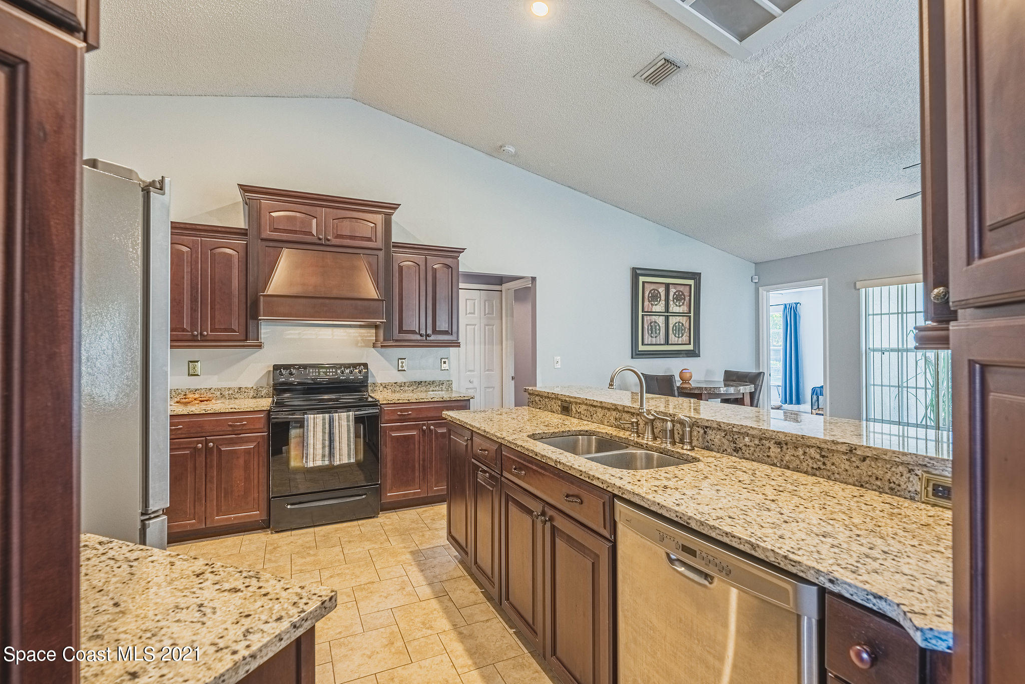 7207 Achilles Road Cocoa, FL 32927 - Photo 16 of 57 a kitchen with granite countertop a sink stove and refrigerator