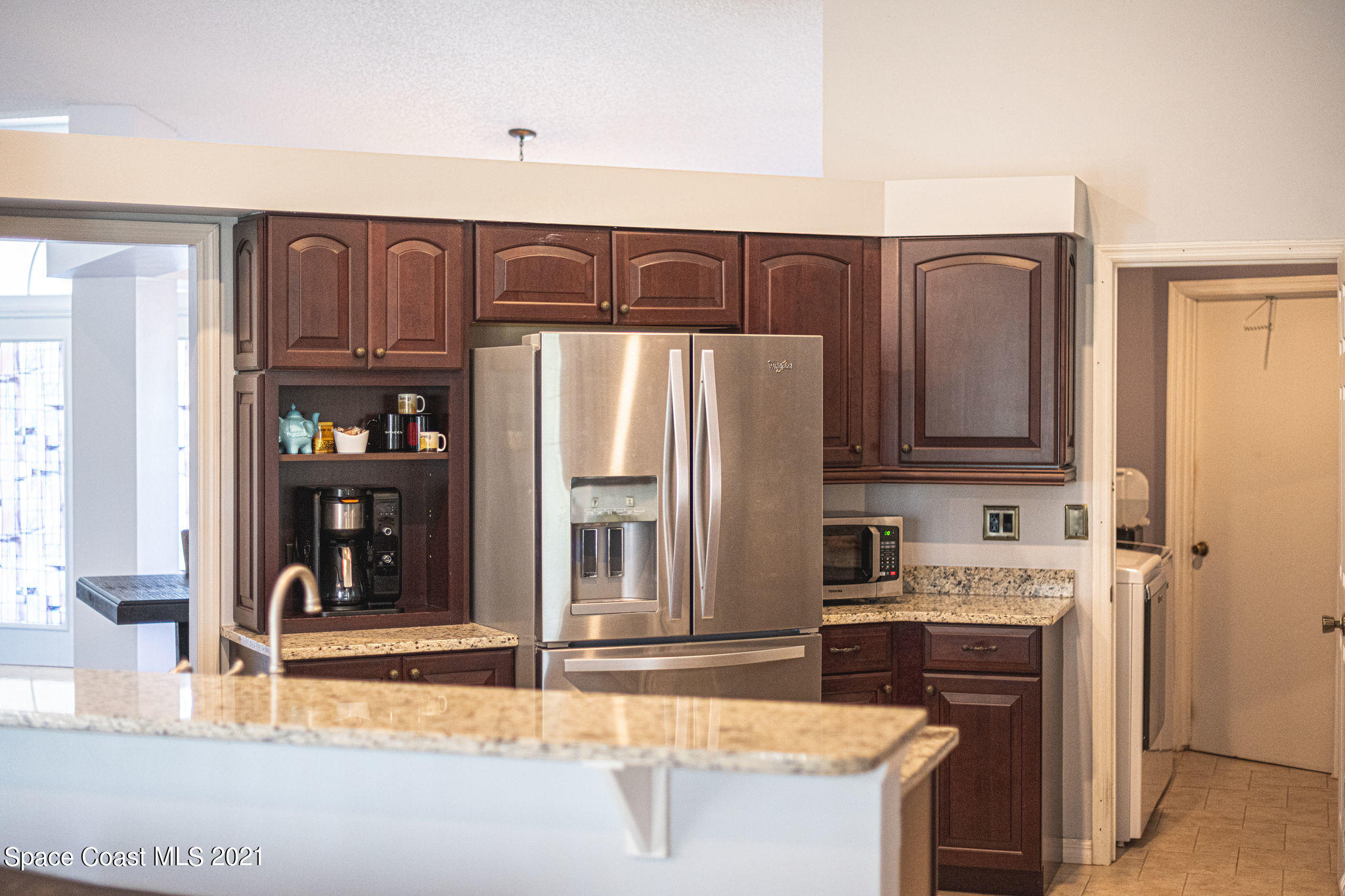 7207 Achilles Road Cocoa, FL 32927 - Photo 19 of 57 a kitchen with kitchen island granite countertop a refrigerator stove and sink