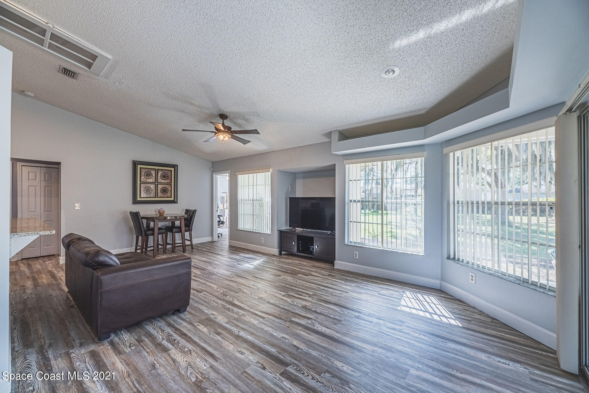 7207 Achilles Road Cocoa, FL 32927 - Photo 35 of 57 a living room with furniture and a flat screen tv