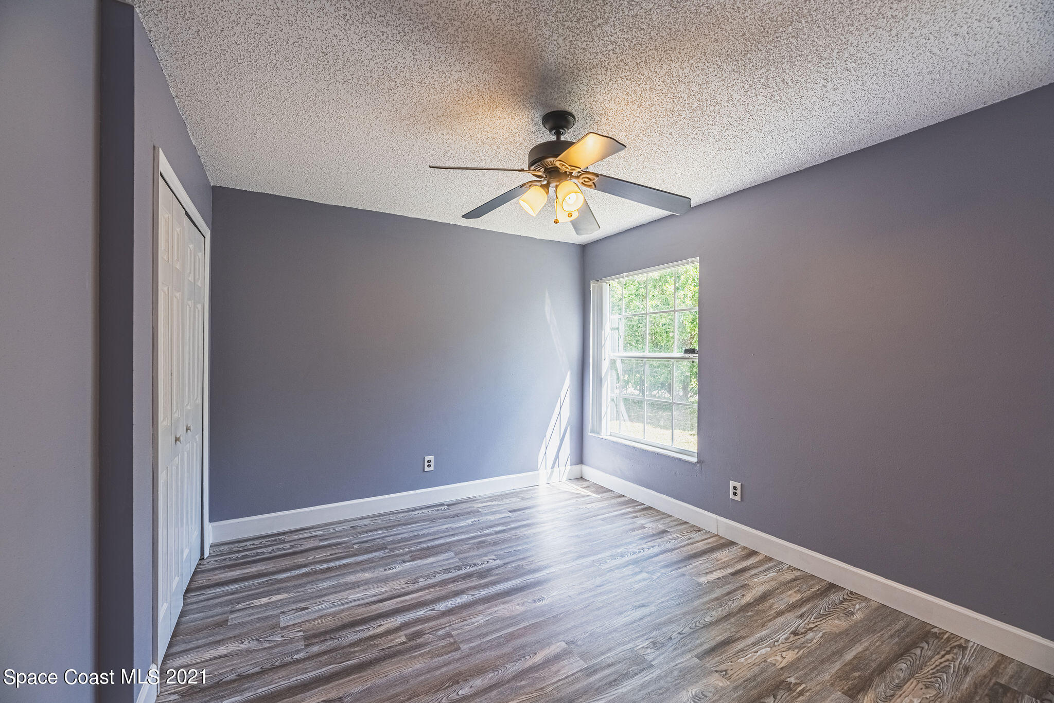 7207 Achilles Road Cocoa, FL 32927 - Photo 36 of 57 a view of an empty room with window and wooden floor