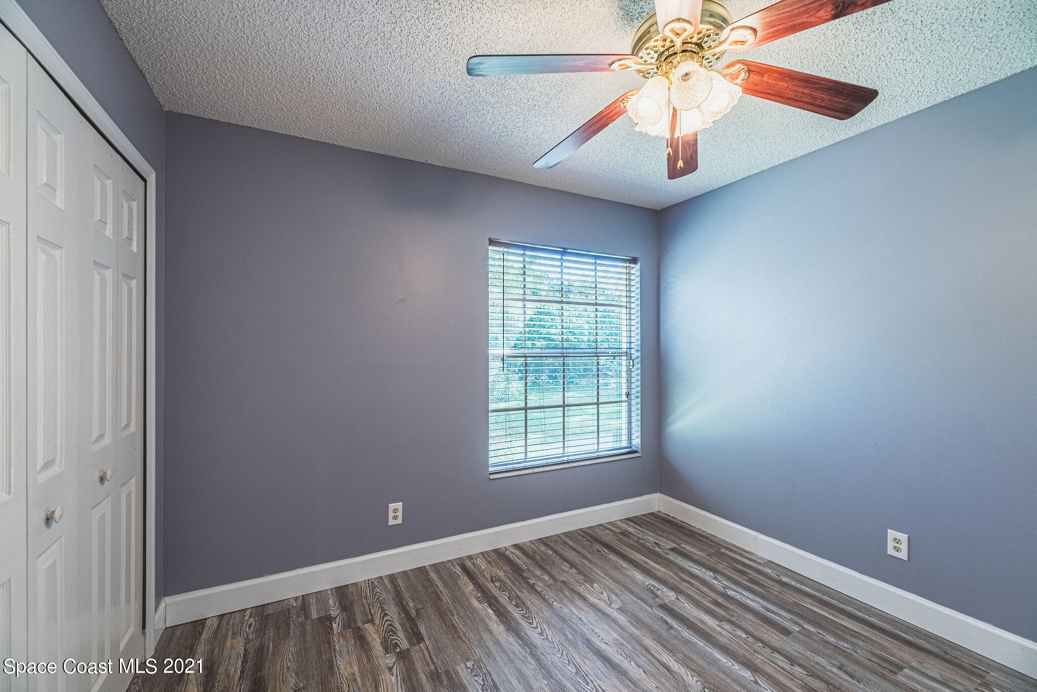 7207 Achilles Road Cocoa, FL 32927 - Photo 37 of 57 a view of an empty room with window and chandelier fan