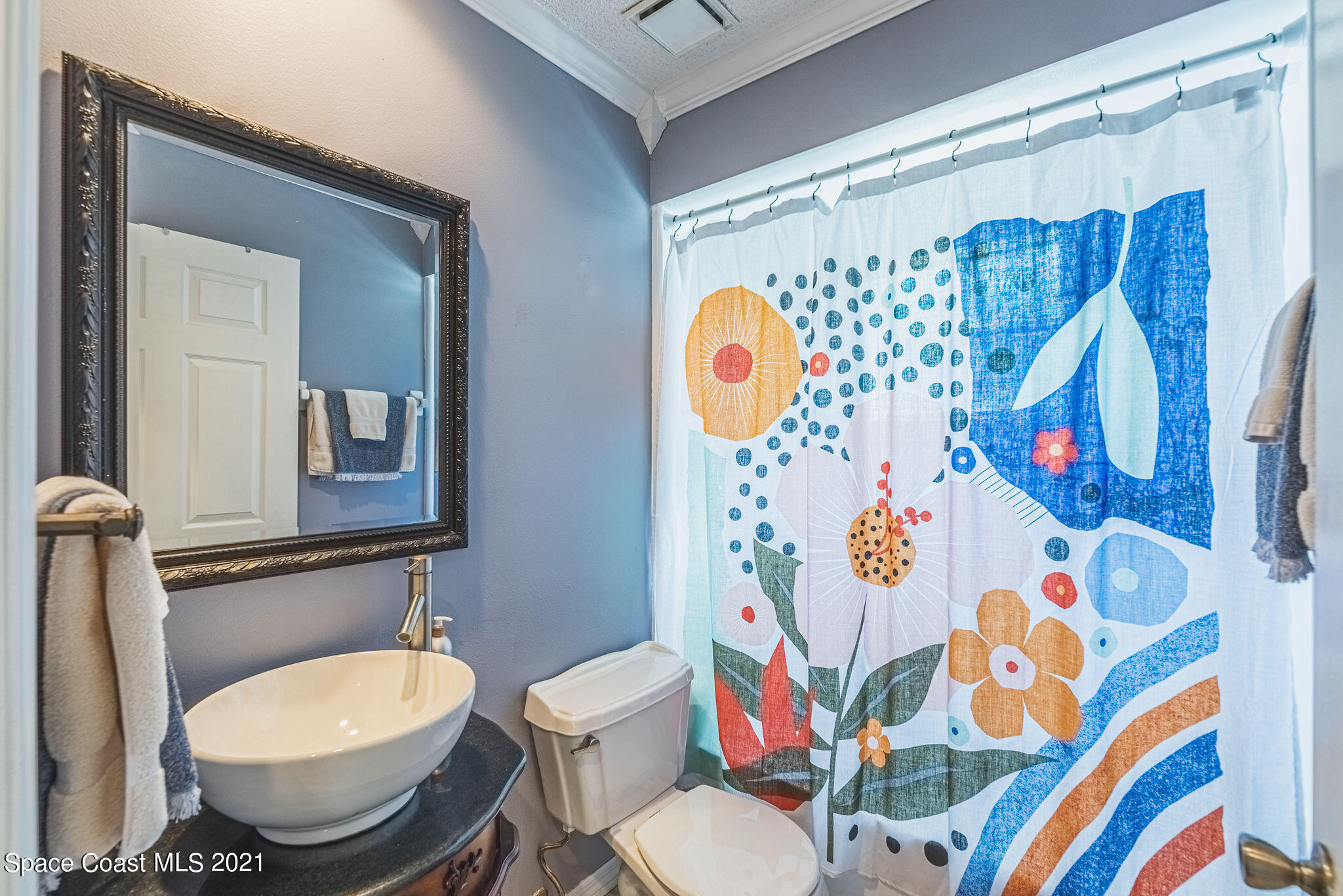 7207 Achilles Road Cocoa, FL 32927 - Photo 40 of 57 a bathroom with a toilet sink and shower curtain