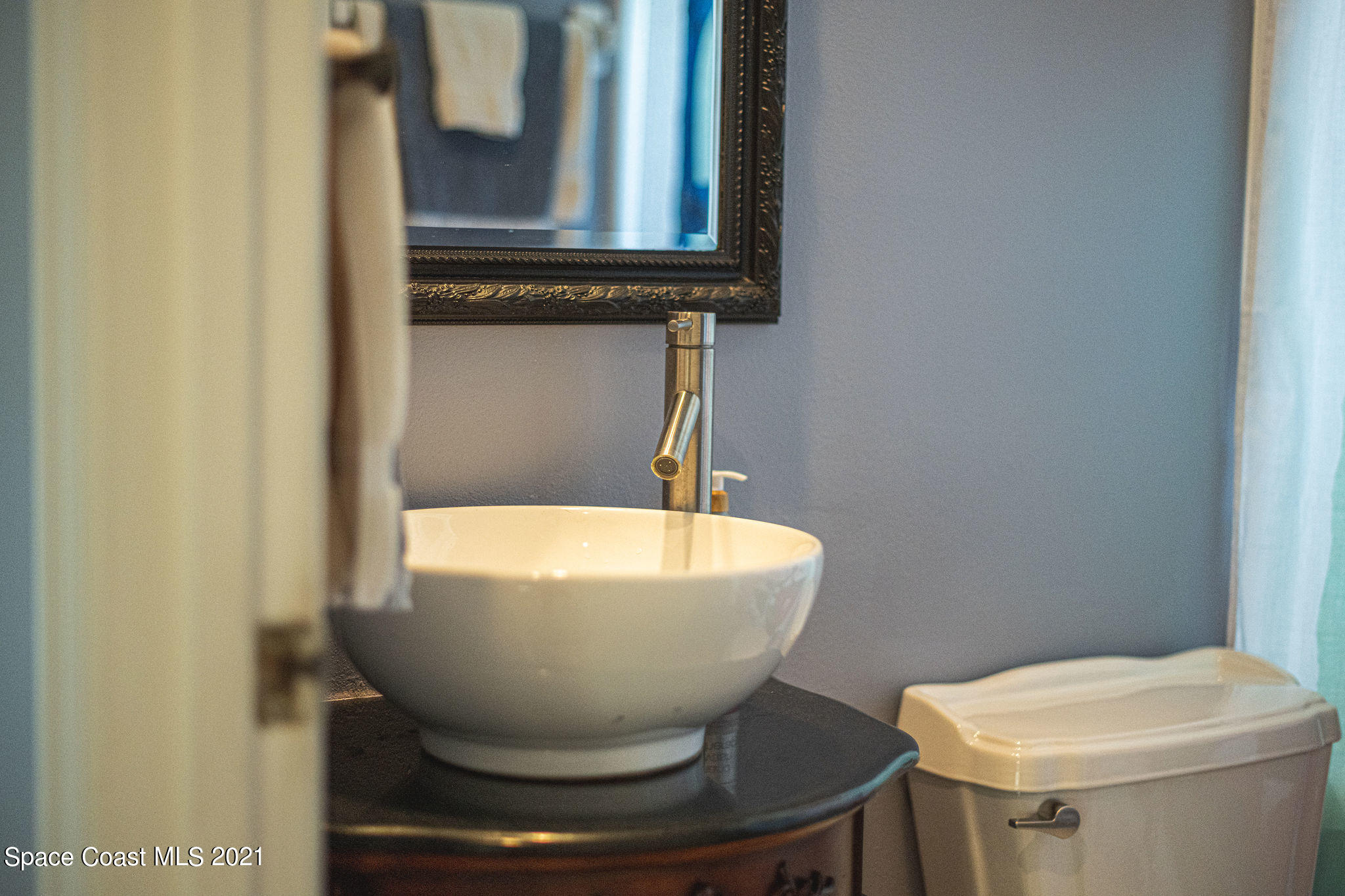 7207 Achilles Road Cocoa, FL 32927 - Photo 41 of 57 a bathroom with a toilet sink and mirror