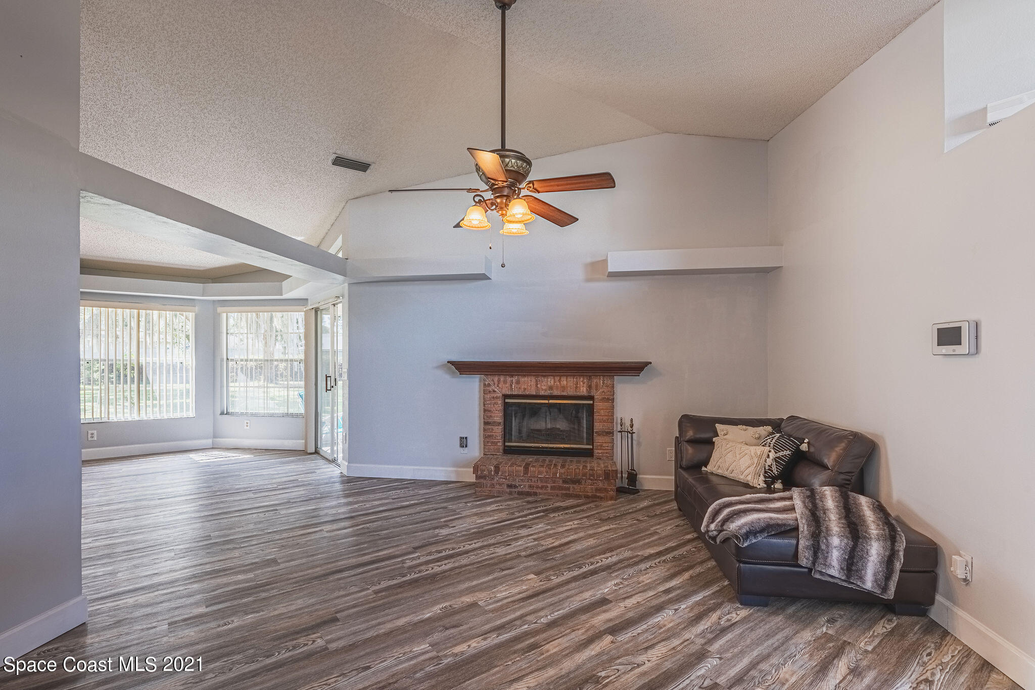 7207 Achilles Road Cocoa, FL 32927 - Photo 9 of 57 a living room with furniture and a fireplace