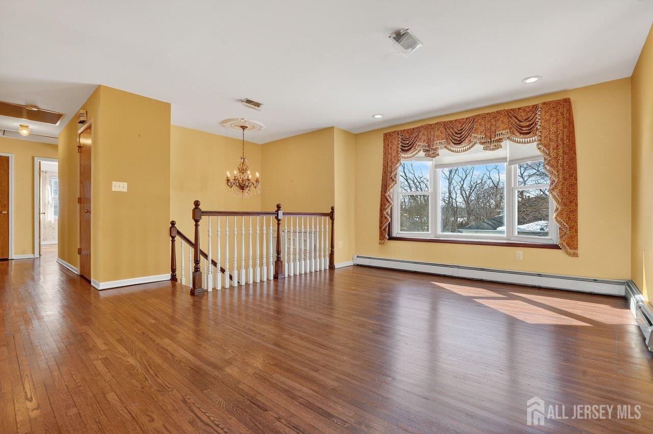 1 Wakefield Drive Edison, NJ 08820 - Photo 5 of 29 a view of an empty room with window and wooden floor