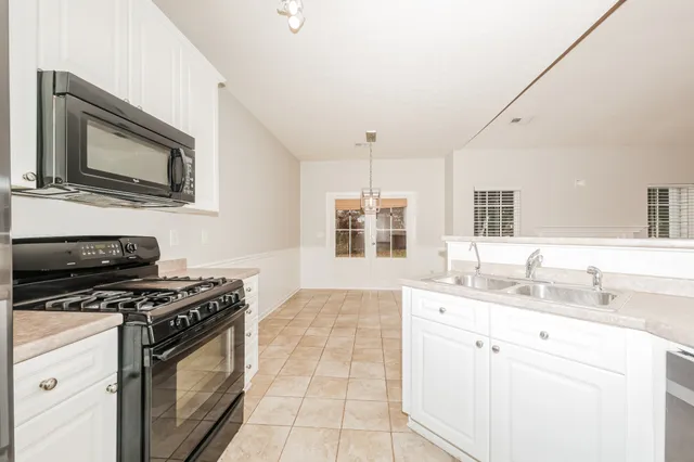 a kitchen with stainless steel appliances a stove microwave and sink