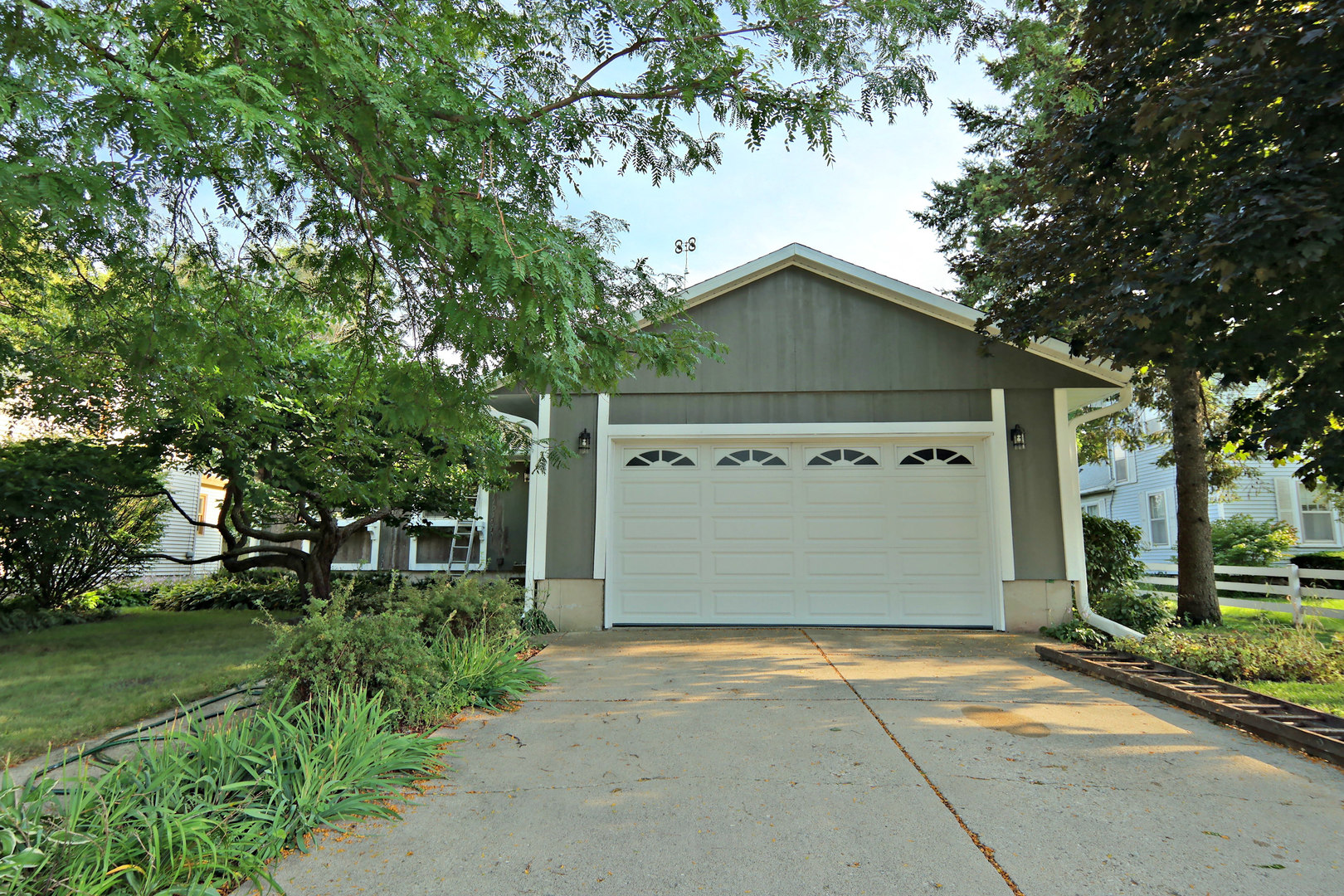a front view of a house with a garden and garage