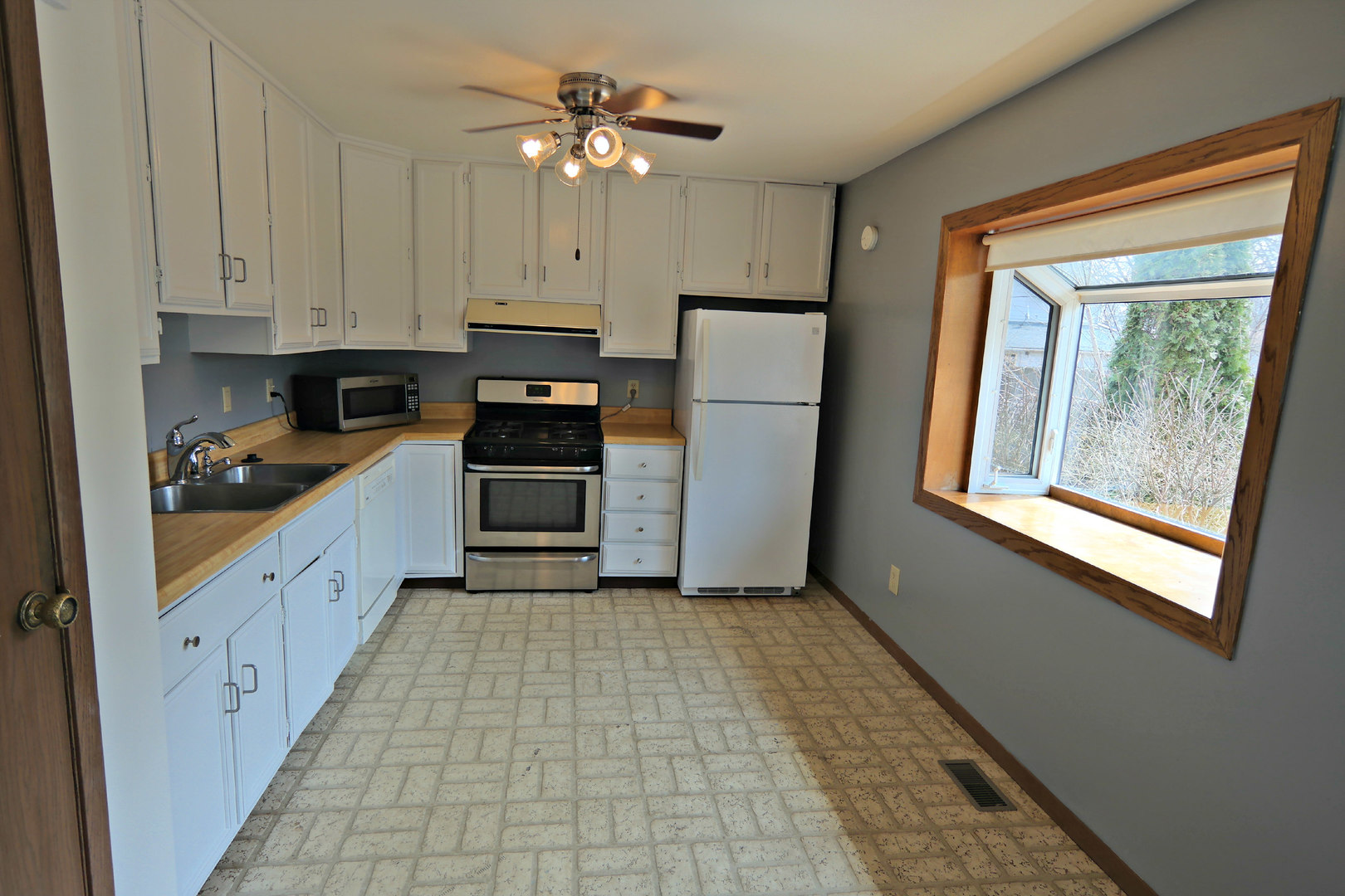 12005 Maple Avenue Hebron, IL 60034 - Photo 5 of 28 a large kitchen with a refrigerator a stove a microwave and cabinets