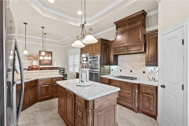 a kitchen with stainless steel appliances granite countertop a sink a stove and a refrigerator