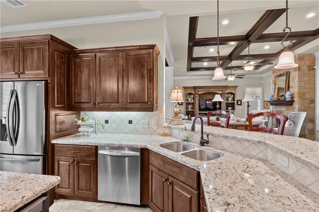 a kitchen with stainless steel appliances granite countertop a sink a stove and a refrigerator