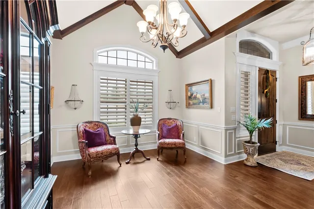 a living room with furniture a wooden floor and a chandelier
