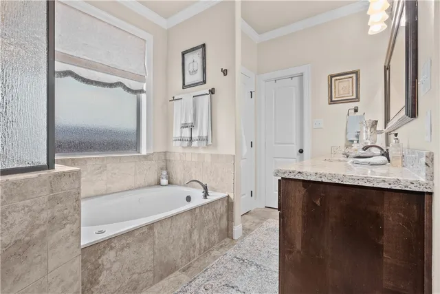 a bathroom with a granite countertop bathtub sink vanity and mirror