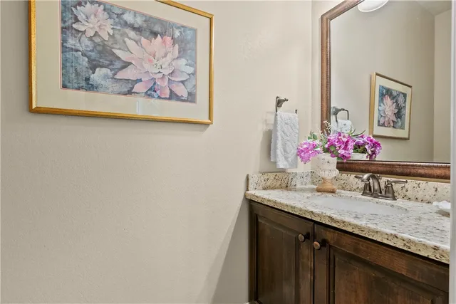 a bathroom with a granite countertop sink with a mirror