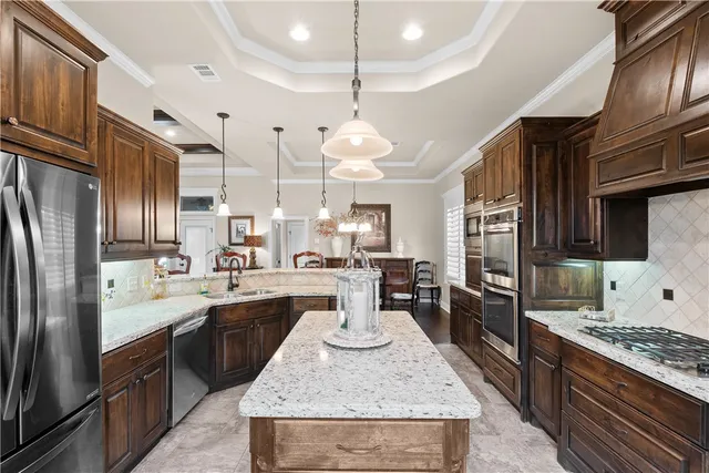 a kitchen with stainless steel appliances granite countertop a stove oven and a refrigerator