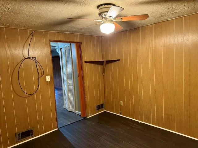 an empty room with closet and a ceiling fan