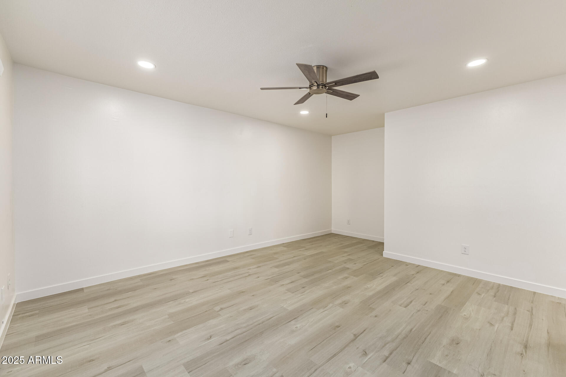 7126 North 19th Avenue, Unit 224 Phoenix, AZ 85021 - Photo 9 of 37 an empty room with wooden floor fan and windows