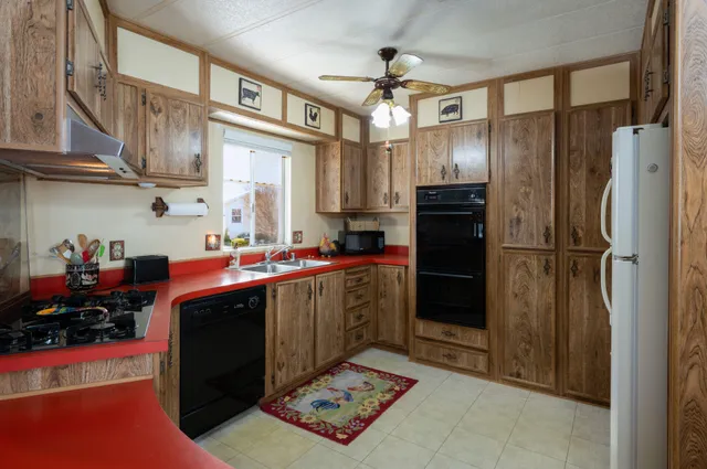 a kitchen with stainless steel appliances granite countertop a refrigerator a stove and a sink