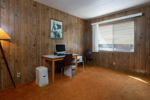 a view of a workspace with furniture and a window
