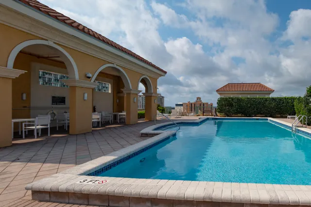a view of swimming pool with a lounge chair and floor to ceiling window