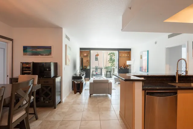 a kitchen with stainless steel appliances granite countertop a stove top oven a sink a dining table and chairs