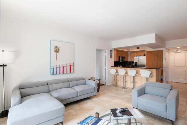 a living room with furniture and view of kitchen