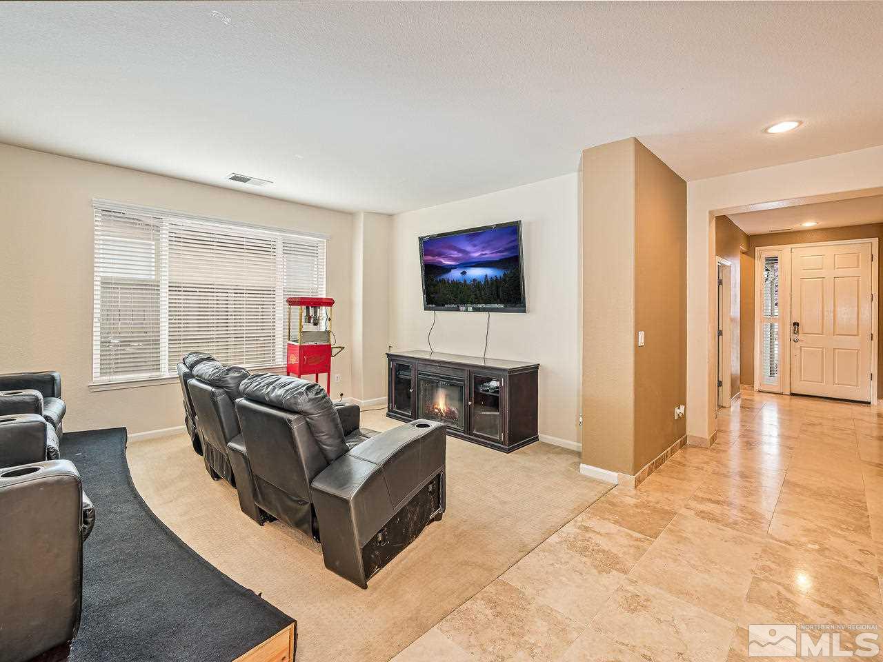521 Secretariat Court Reno, NV 89521 - Photo 6 of 25 a living room with furniture a flat screen tv and a fireplace