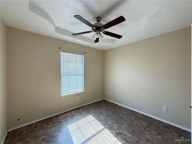a view of a big room with windows and ceiling fan
