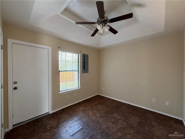 an empty room with a window and a fan