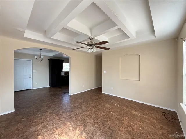 an empty room with a ceiling fan and a window