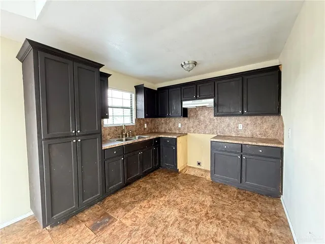 a kitchen with granite countertop stainless steel appliances a refrigerator and cabinets