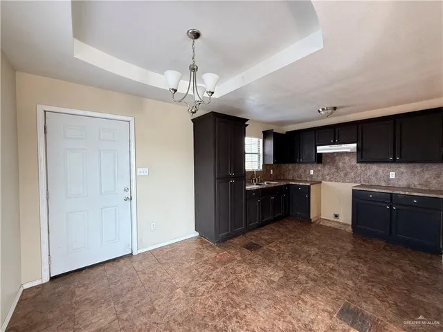 a large kitchen with a stove a sink and a refrigerator