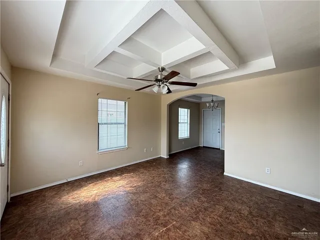 an empty room with windows and ceiling fan