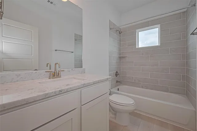 a bathroom with a granite countertop toilet a sink and bathtub