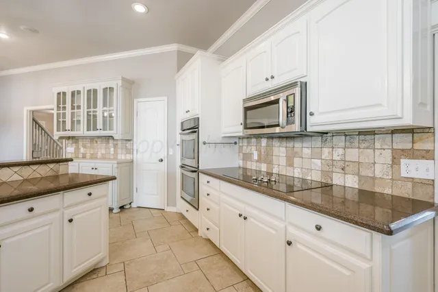 an empty room with windows and chandelier fan