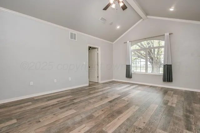 a view of an empty room with closet and a window
